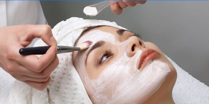 A kozmetikus tisztítószereket alkalmaz a beteg arcára