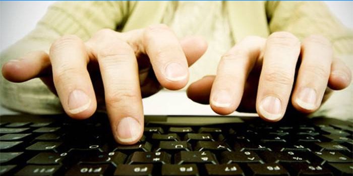 Egy ember ujjai a számítógép billentyűzet felett