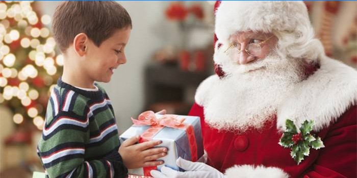 A Mikulás ajándékot ad egy fiúnak az új évre